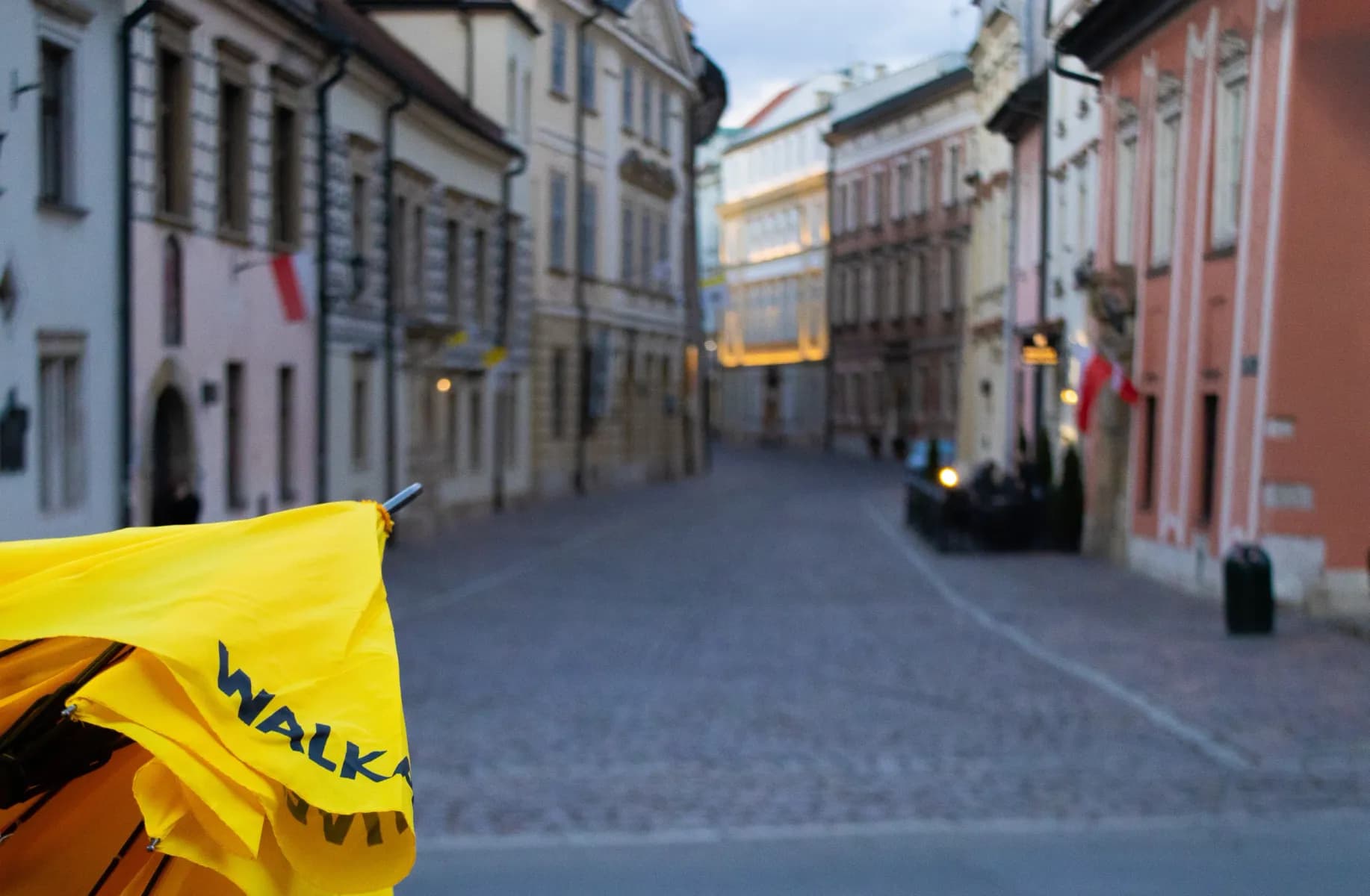 Przewodnik Walkative z parasolem na ulicy Starego Miasta w Krakowie